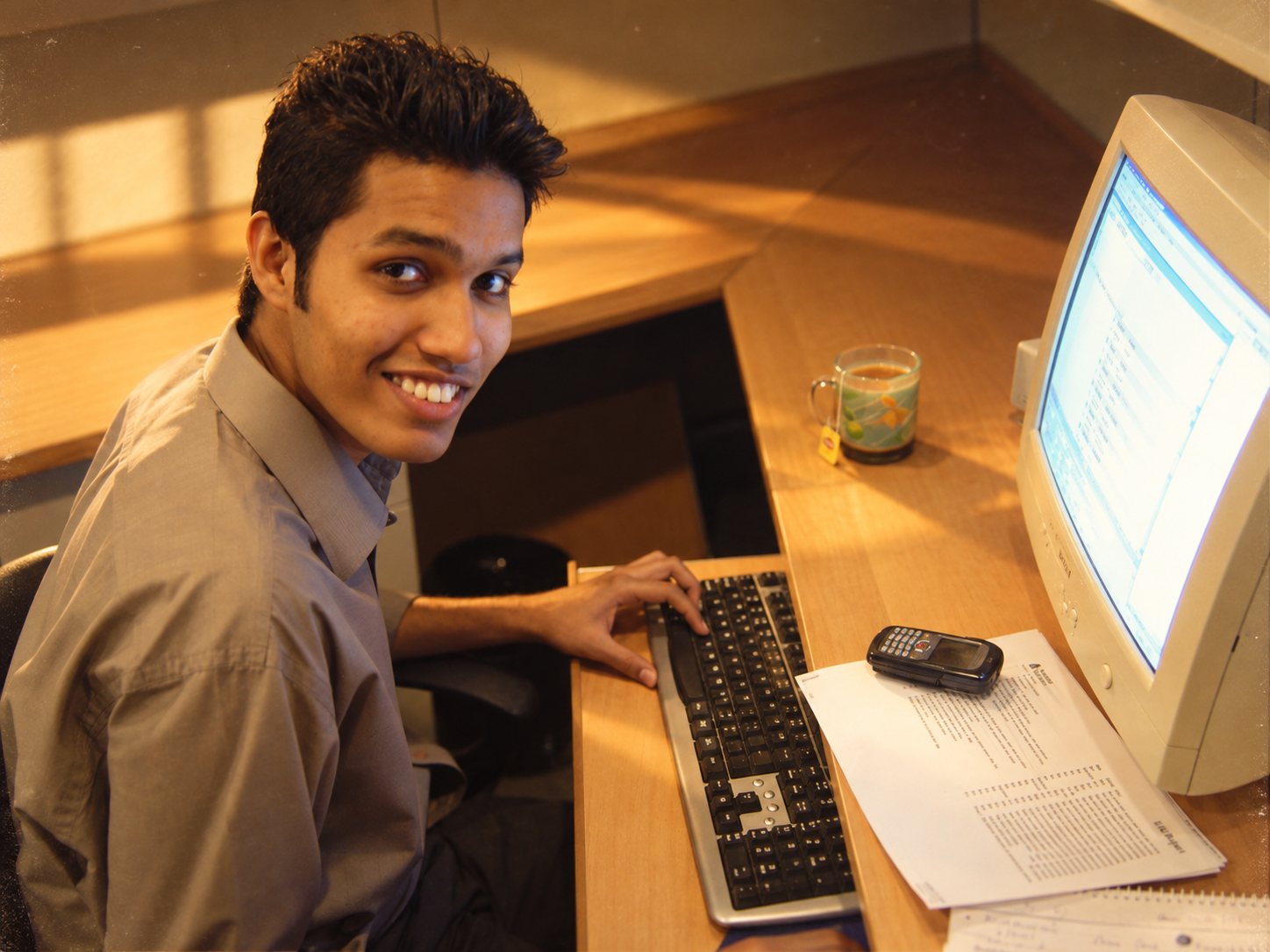 Zair in 2006, smiling at his office desk beside a CRT monitor