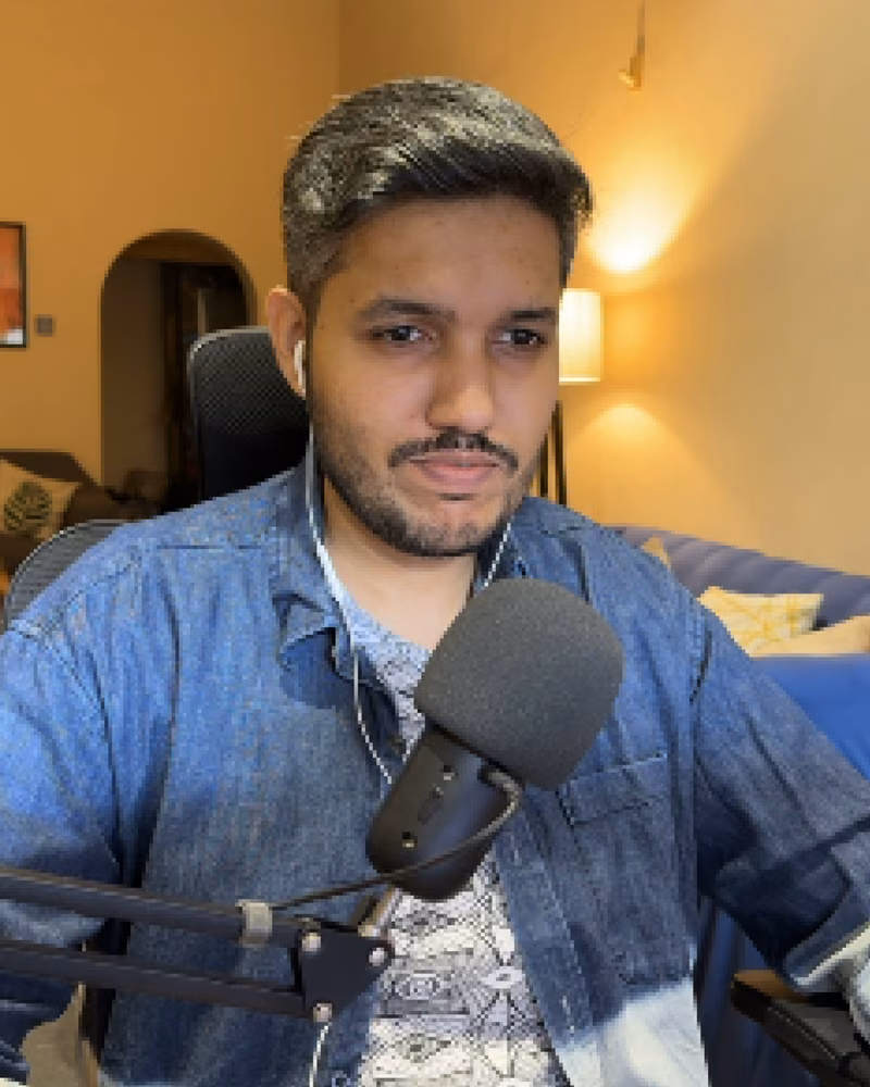 Zair at his desk with a microphone, recording